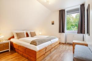a bedroom with a wooden bed with a window at Südstranddomizil 56 in Wyk auf Föhr