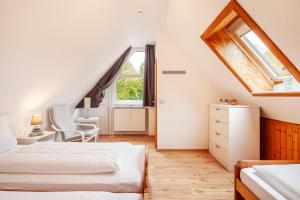 a attic bedroom with two beds and a window at Südstranddomizil 56 in Wyk auf Föhr