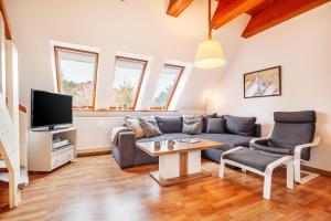a living room with a couch and a tv at Südstranddomizil 56 in Wyk auf Föhr