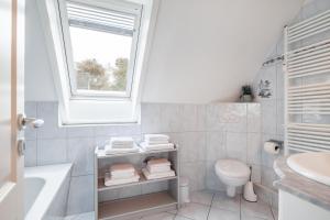 a bathroom with a sink toilet and a window at Südstranddomizil 56 in Wyk auf Föhr