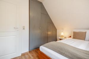 a bedroom with a white bed and a closet at Südstranddomizil 56 in Wyk auf Föhr +8 photos