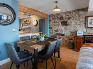 een keuken en eetkamer met een houten tafel en stoelen bij Shorefront Apartment in Anstruther