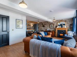 een woonkamer met twee banken en een open haard bij Shorefront Apartment in Anstruther