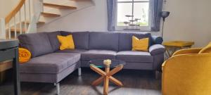 a living room with a blue couch and yellow pillows at Reethaus "Melsa" in Zierow