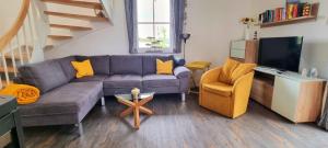 a living room with a couch and a chair at Reethaus "Melsa" in Zierow