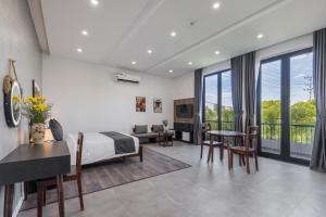 ein Schlafzimmer mit einem Bett, einem Tisch und Stühlen in der Unterkunft Anchie Retreat Villa Hội An in An Bàn (2)