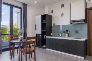 eine Küche mit Tisch und Stühlen und einer Theke in der Unterkunft Anchie Retreat Villa Hội An in An Bàn (2)