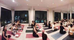 een groep mensen die in een kamer yoga doen bij Fun Hotel in Ban Thai Wat Khot