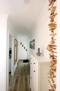 a hallway with white walls and a staircase with rocks at Meer-Liebe in Hörnum