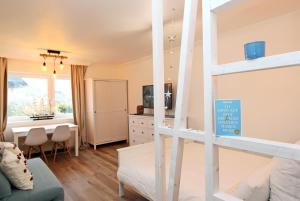 a bedroom with a bunk bed and a dining room at Meer-Liebe in Hörnum