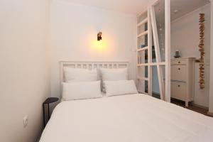 a white bed with white pillows in a room at Meer-Liebe in Hörnum