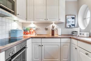 a kitchen with white cabinets and wooden counter tops at Hüs Lillebo in Hedehusum
