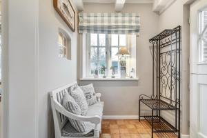 a white rocking chair in a hallway with a window at Hüs Lillebo in Hedehusum +35 photos
