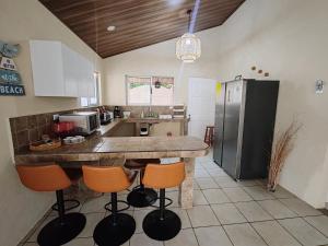 a kitchen with a large counter with orange bar stools at Casa Tribu in Agujas