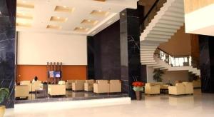 eine Lobby mit Tischen und Stühlen in einem Gebäude in der Unterkunft Grand Antares Hotel in Polonia Airport
