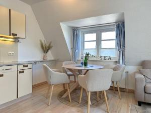 a kitchen and dining room with a table and chairs at Sinfonie, Whg 5 in Tinnum