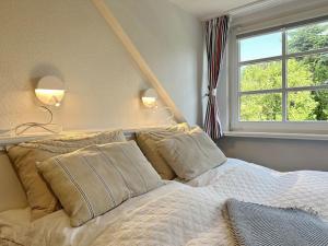 a bedroom with a bed with pillows and a window at Sinfonie, Whg 5 in Tinnum +14 photos