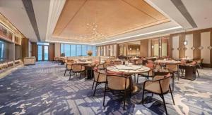 ein Restaurant mit Tischen und Stühlen in einem Raum in der Unterkunft Dongguan Yingbin Hotel in Dongguan