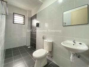 une salle de bains blanche avec toilettes et lavabo dans l'établissement Seri Centuarea Homestay, Seri Iskandar, à Seri Iskandar 4 autres photos