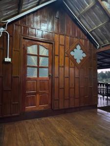 a large wooden barn with a door at NADOHN-Homestay in Ban Nam Lai Ta Tum