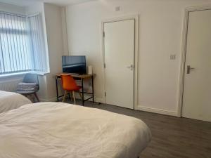 een slaapkamer met een bed en een bureau met een computer bij Serene Studio in Dudley in Dudley