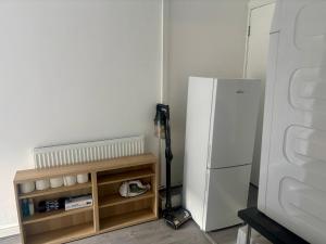 een keuken met een witte koelkast naast een plank bij Serene Studio in Dudley in Dudley