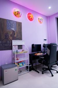 an office with purple walls and a desk and a computer at 1993 Homestay G&C Quảng Trị in Quang Tri +20 photos