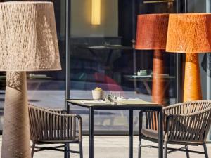 een tafel met twee stoelen en een tafel met twee lampen bij Hotel Giacomo Morra Alba - Handwritten Collection in Alba