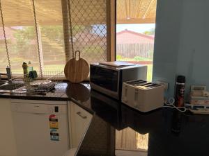 een keuken met een aanrecht met een magnetron bij Perfect home Nice location quiet holiday home with beautiful yard in Perth +12 foto's