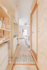 a kitchen with white walls and a floor with white shoes on the floor at Hotel Emile102 in Tachikawa +48 photos