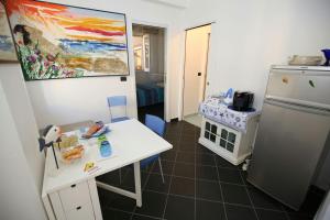 a kitchen with a white table and a refrigerator at Stop And Go in Scilla