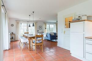 una cucina e un soggiorno con tavolo e sedie di Haus Traumstraße a Hedehusum Altre 23 foto