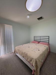 een slaapkamer met een bed en een groot raam bij Perfect home Nice location quiet holiday home with beautiful yard in Perth