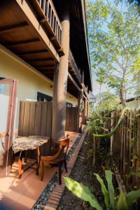 een veranda van een huis met een tafel en een bank bij Bualuang Hotel in Luang Prabang