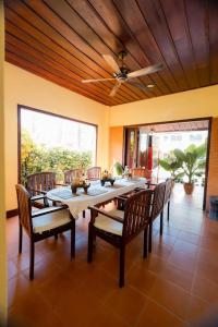 een eetkamer met een tafel en stoelen en een plafondventilator bij Bualuang Hotel in Luang Prabang