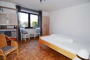 a bedroom with a bed and chairs and a table at Breslauer Haus in Heiligenhafen