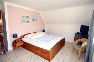 a bedroom with a large bed and a television at Breslauer Haus in Heiligenhafen +9 photos