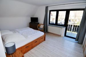 a bedroom with a bed and a large window at Breslauer Haus in Heiligenhafen