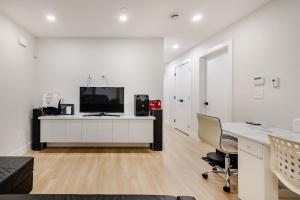 een kantoor met een bureau en een tv aan een witte muur bij Metrotown area in Vancouver