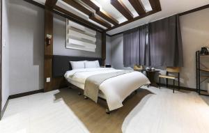 una camera da letto con un letto grande in una stanza di 천안 호텔 하루 a Tujŏng-dong