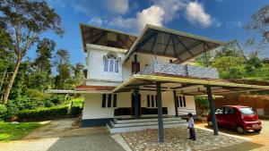 a man standing in front of a house at Karmalhills Homestay in Tindummal