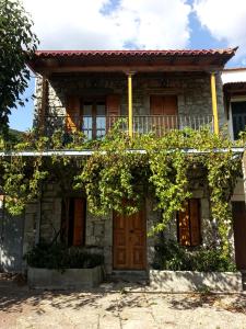 ein altes Steinhaus mit Reben darauf in der Unterkunft Stephania's Stone House in Karyes