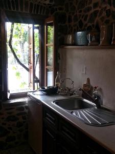 a kitchen with a sink and a window at Stephania's Stone House in Karyes