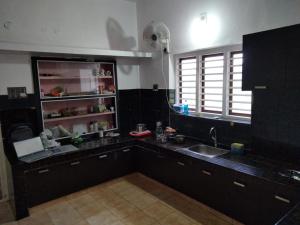 a kitchen with a sink and a counter top at Karmalhills Homestay in Tindummal +13 photos