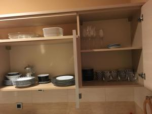 a cupboard with plates and dishes in it at Zaga Solemar Apartment in Herceg-Novi
