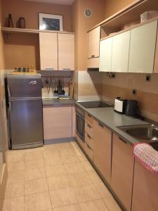 a kitchen with white cabinets and a stainless steel refrigerator at Zaga Solemar Apartment in Herceg-Novi