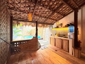 een kamer met een hangmat in een kamer met een keuken bij Lugadia Villas in El Nido