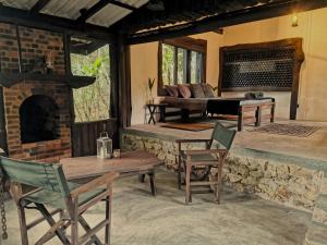 a living room with a fireplace and tables and chairs at The Trogon Knuckles in Rangala +90 photos
