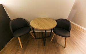 due sedie e un tavolo in legno in una stanza di 천안 호텔 하루 a Tujŏng-dong