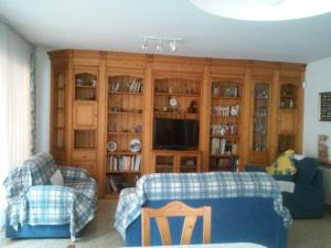 a living room with two couches and a tv at Apartamentos Montserrat in Blanes